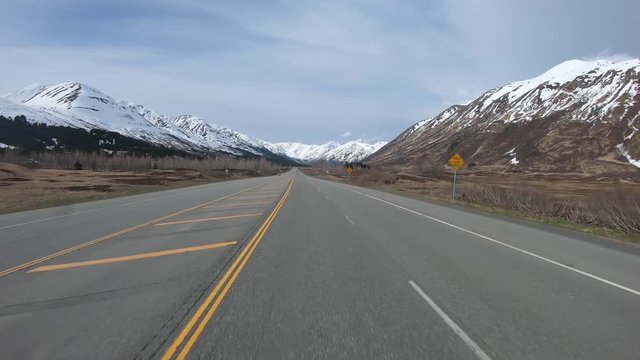POV; Driving the Seward Highway through the Chugach National Forest through the Ingram Creek Valley along in Alaska, with Chugach Mountains on either side of the valley
