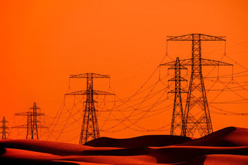 Silhouette of high voltage towers in the desert during sunset