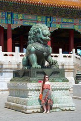 Cool fashionable female western tourist posing with Chinese dragon statue