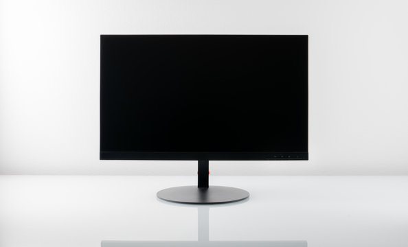 Monitor with blank screen on a white glass table with reflection