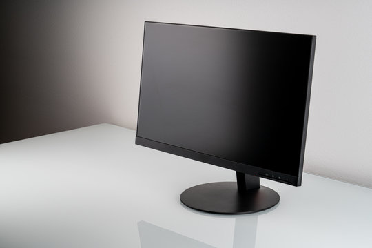 Monitor with blank screen on a white glass table