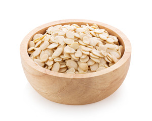 pumpkin seeds in wood bowl isolated on white background. full depth of field