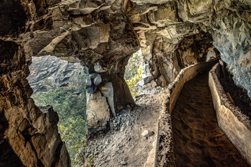 An old aqueduct now used as an adventure hiking trail Guimar valley. Trail in the fog through the mysterious mountains and caves. Tenerife, Spain