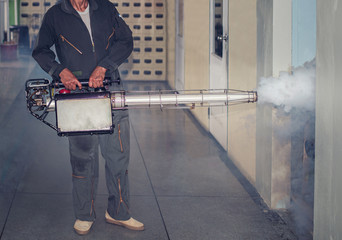 Man spraying fogging, eliminating mosquitoes, stopping the spread of dengue fever
