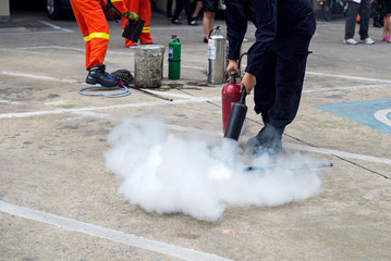 Hand holding fire extinguisher and spraying to the burning fire