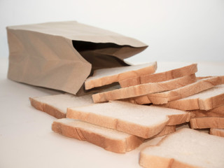 Bread full sliced in paper bag isolated on white background.