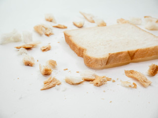 Fototapeta na wymiar Scattered bread crumbs and Sliced Bread on white table background.