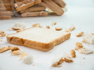 Fototapeta na wymiar Scattered bread crumbs and Sliced Bread on white table background.