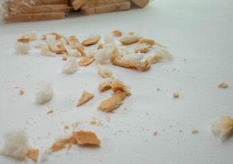 Fototapeta na wymiar Scattered bread crumbs on white table background.