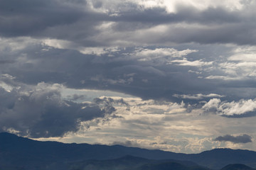 The Dark gray dramatic sky with large clouds on mountain in rainy seasons.