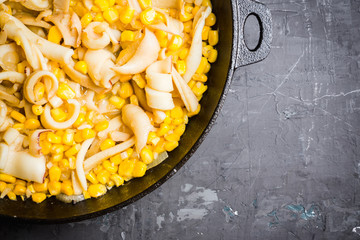 Squid warm salad with onion and corn. Selective focus. Shallow depth of field. © maxandrew