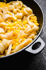 Squid warm salad with onion and corn. Selective focus. Shallow depth of field.