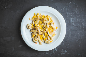Squid warm salad with onion and corn. Selective focus. Shallow depth of field. © maxandrew