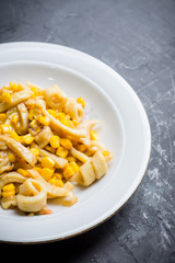 Squid warm salad with onion and corn. Selective focus. Shallow depth of field.