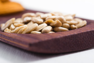 dried fruits and spices on wooden tray, white table