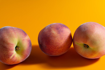 juicy fresh ripe peach on orange matte background