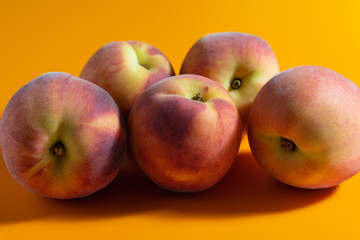 juicy fresh ripe peach on orange matte background