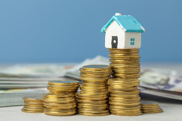 Stack of coins and an old house. Concept of expensive home repair service