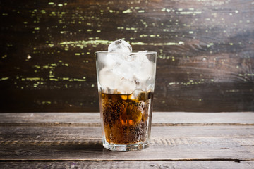 Refreshing cold cherry cola on the wooden background. Selective focus.