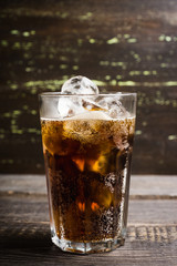 Refreshing cold cherry cola on the wooden background. Selective focus.
