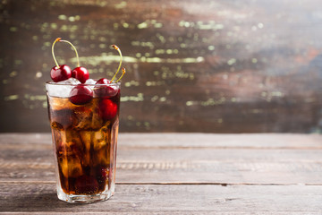 Refreshing cold cherry cola on the wooden background. Selective focus. - obrazy, fototapety, plakaty