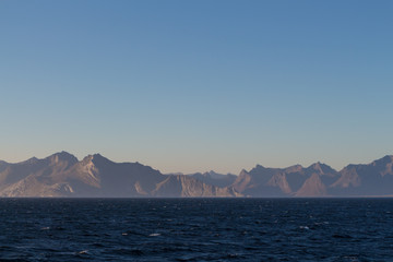 Naklejka na ściany i meble Norwegian fjords with rocky horizon at sunrise