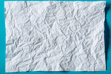 White crumpled paper on blue background
