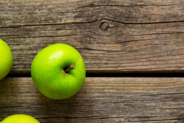 green apples on old wooden background