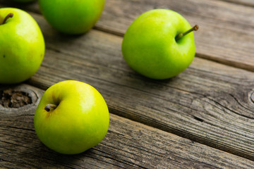 green apples on old wooden background