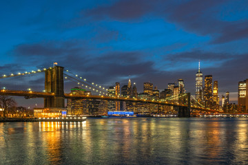 Obraz na płótnie Canvas scene of New york Cityscape with Brooklyn Bridge over the east river at the twilight time, USA downtown skyline, Architecture and transportation concept