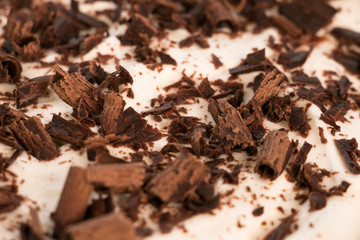 Plano detalle de chocolate rayado sobre la crema de una torta deliciosa