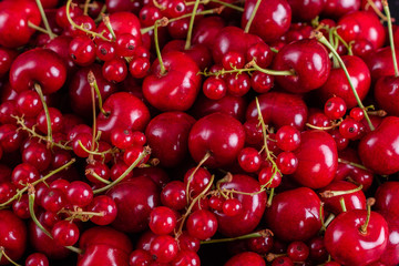 Sweet fresh organic cherry background close-up. Cherry in the plate with leaves on a dark background