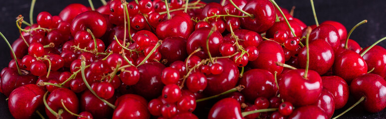 Sweet fresh organic cherry background close-up. Cherry in the plate with leaves on a dark background