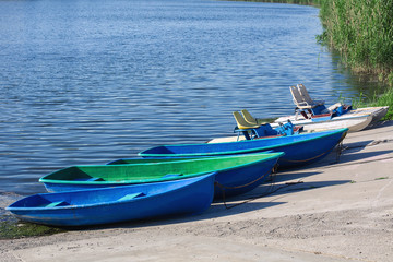 boats and catamarans on the shore of the blue pond