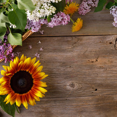 The decor of flowers on the background of vintage wooden planks. Vintage background with flowers of dandelion sunflower and lilac and a place under the text. Flat lay. Vintage.