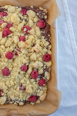Closeup of chocolate cake with raspberry and streusel on a table