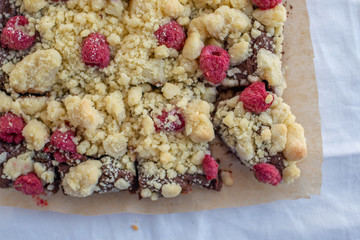 Closeup of chocolate cake with raspberry and streusel on a table
