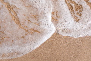 Wet sand and sea foam background