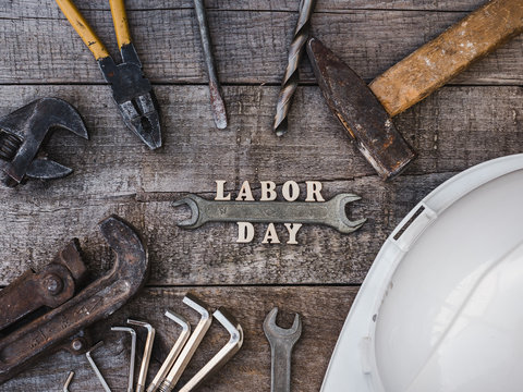 LABOR DAY. Hand tools and wooden letters lying on the table. Top view, close-up. Preparing for the celebration. Congratulations to loved ones, family, relatives, friends and colleagues