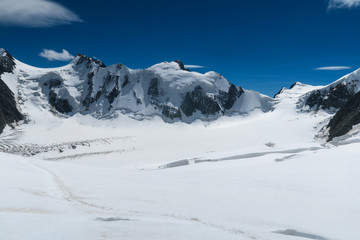 Mountain climbers walking on the glacier near the crack. View to the Mensu glacier. Belukha Mountain area. Altai, Russia.