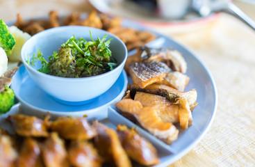 Northern Thai Green Chilli Dip (Nam Prik Num) in blue bowl served with fried fish and boiled vegetables.