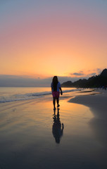 A lone girl walking on a beach