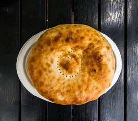 Pita bread on a black table, top view, flat lay