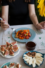 A tasty dinner: a salad, plates of sulguni cheese, fig slices and white bread sandwiches.