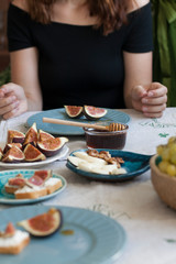 A tasty snack: plates of sulguni cheese, fig slices and white bread sandwiches.