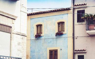 Facade wall of old baroque residential building houses in Acitrezza, traditional architecture of Sicily, Italy.
