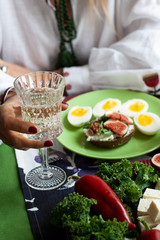 A gourmet lunch: a rye bread sandwich, cheese bites, sliced figs and boiled eggs.