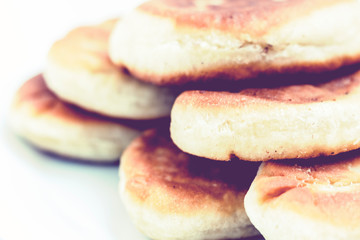 Fried cakes with potato and beans on white table background .