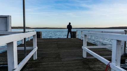 Mann steht auf Seebrücke am Plauer See