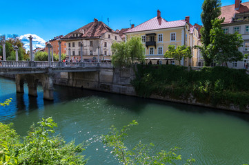 Fototapeta na wymiar Ljubljanica River as it passes through the city of Ljubljana, with the Cobblers bridge in the picture, Slovenia
